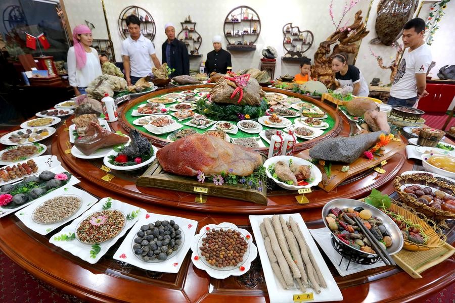 Des visiteurs admirent des plats faits en pierre lors d’une exposition dans la préfecture de Hami, lundi dans la Région autonome ou?goure du Xinjiang. [Photo / Xinhua] 