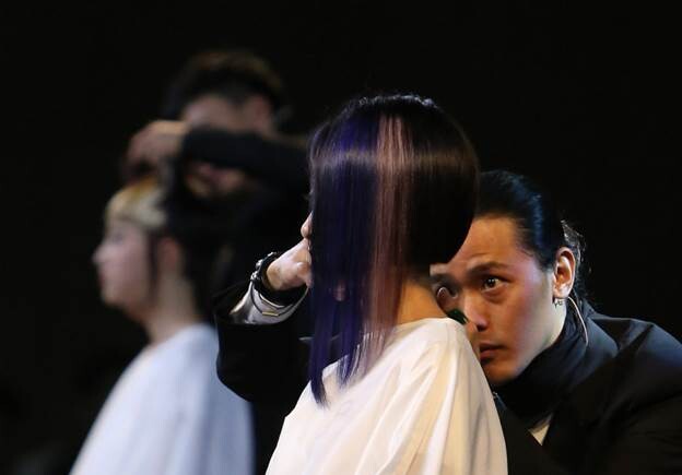 Un coiffeur travaille sur la chevelure d'un mannequin lors de la 9e édition du Festival Asiatique de Coiffure, mercredi à Shanghai. Le festival, qui a débuté mercredi et se termine vendredi, propose une série d'événements, comme un concours de coiffure et des sessions de formation. [Photo Gao Erqiang / Asianewsphoto]