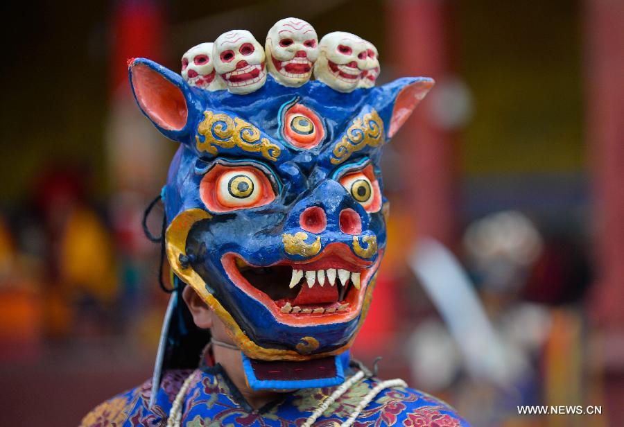 Un lama portant un masque effectue la danse du sorcier au Temple Drigong Ti, dans le Comté de Maizhokunggar, à Lhassa (Région autonome du Tibet, dans le Sud de la Chine), le 25 juin 2014. 