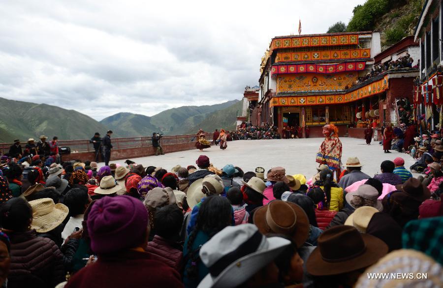 Des spectateurs regardent les lamas effecteur la danse du sorcier au Temple Drigong Ti, dans le Comté de Maizhokunggar, à Lhassa (Région autonome du Tibet, dans le Sud de la Chine), le 25 juin 2014. 