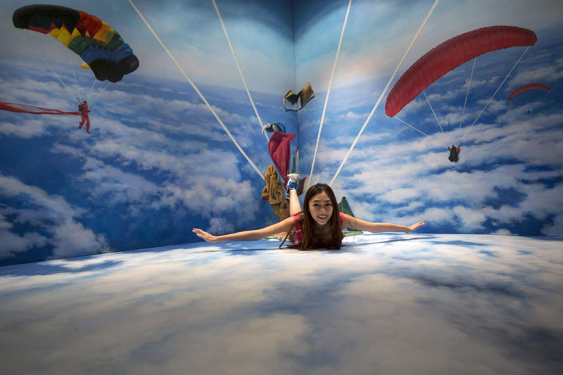 Une femme pose pour la photo devant une peinture 3D au musée 3D de Hong Kong, le 26 juin 2014.