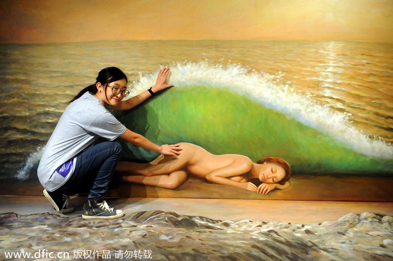 Une femme pose pour la photo devant une peinture 3D au musée 3D de Hong Kong, le 26 juin 2014.