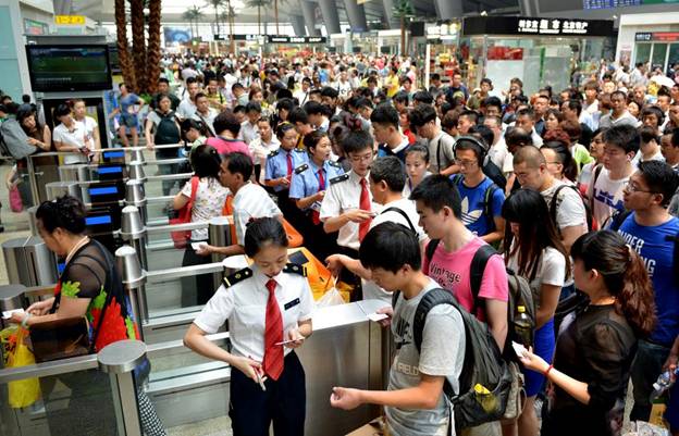 Des passagers passent au contr?le des billets pour prendre un train CRH, exploité sur la ligne à grande vitesse Beijing-Shanghai, à la Gare du Sud de Beijing, capitale de la Chine, le 30 juin 2014. La liaison ferroviaire à grande vitesse Beijing-Shanghai (ou Jinghu) a célébré le troisième anniversaire de sa mise en service lundi. La ligne de 1 318 kilomètres qui relie Beijing, la capitale de la Chine, et Shanghai, la plus grande ville du pays, a déjà accueilli plus de 220 millions de passagers au cours des trois années qui se sont écoulées depuis ses débuts le 30 juin 2011.