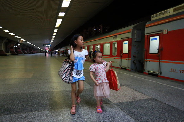 Wu Jinjuan, à gauche, emmène sa s?ur cadette Siyu pour prendre un train de Guilin vers le Guangdong, le 9 juillet 2014.