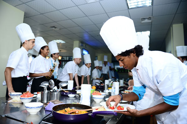 Un joueur de volleyball de plage (à droite) du Guatemala se concentre sur la cuisine, 14 ao?t 2014. [Photo / Xinhua ]