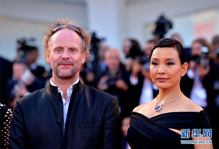 Philip Gr?ning et Joan Chen, deux des membres du jury du festival, sur le tapis rouge de la Mostra, le 27 ao?t au Lido de Venise. Xu Nizhi pour Xinhua.