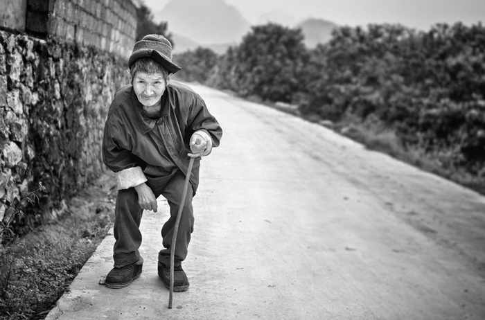 Une personne agée tout sourire devant l’objectif de la photographe.