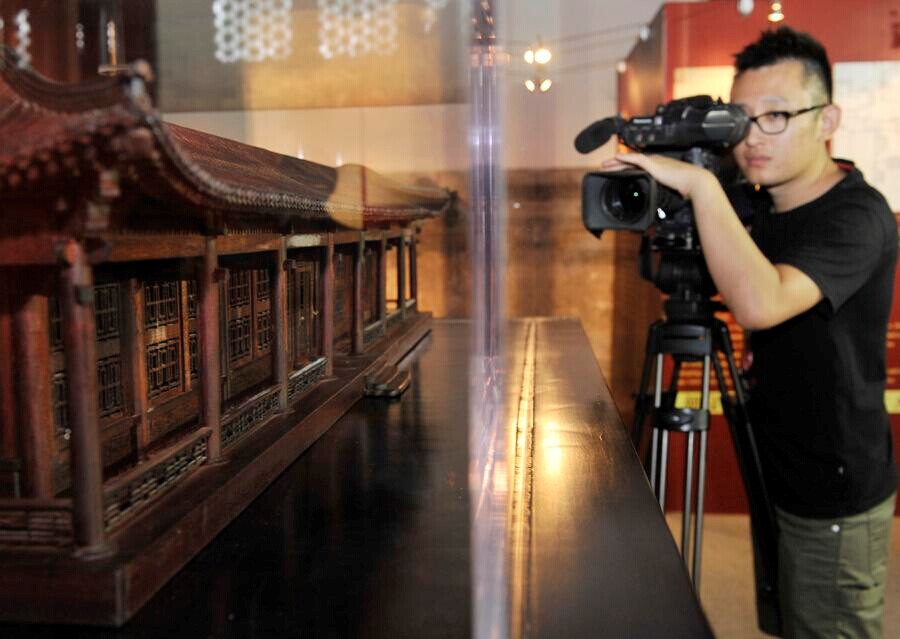 Un caméraman filme une des maquettes en acajou des batiments du Yuanmingyuan.