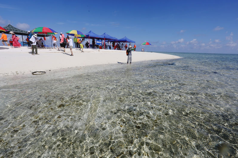 Des touristes profitent de leur voyage à Yinyu, l'une des ?les Xisha dans la province de Hainan dans le sud de la Chine. Le premier groupe de plus de 200 touristes y est venu en visite après la mise en service de la route depuis Sanya. Beach-volley, plongée et pêche en mer, on ne s’ennuiera certainement pas ici. [Photo / Xinhua]