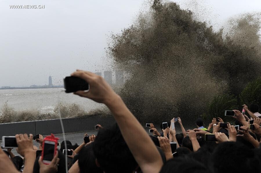 Des spectateurs rassemblés sur les rives du fleuve pour admirer le mascaret de la rivière Qiantang à Yanguan (ville de Haining), dans la Province du Zhejiang à l'Est de la Chine, le 11 septembre 2014. C’est lors du huitième mois du calendrier lunaire chinois que le mascaret de la rivière Qiantang voit déferler les plus hautes vagues. (Xinhua / Han Chuanhao)