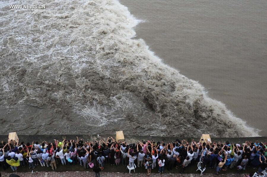 Des spectateurs rassemblés sur les rives du fleuve pour admirer le mascaret de la rivière Qiantang à Yanguan (ville de Haining), dans la Province du Zhejiang à l'Est de la Chine, le 11 septembre 2014. C’est lors du huitième mois du calendrier lunaire chinois que le mascaret de la rivière Qiantang voit déferler les plus hautes vagues. (Xinhua / Han Chuanhao)