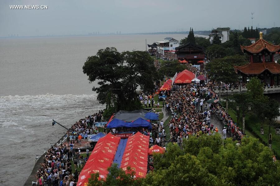 Des spectateurs rassemblés sur les rives du fleuve pour admirer le mascaret de la rivière Qiantang à Yanguan (ville de Haining), dans la Province du Zhejiang à l'Est de la Chine, le 11 septembre 2014. C’est lors du huitième mois du calendrier lunaire chinois que le mascaret de la rivière Qiantang voit déferler les plus hautes vagues. (Xinhua / Han Chuanhao)