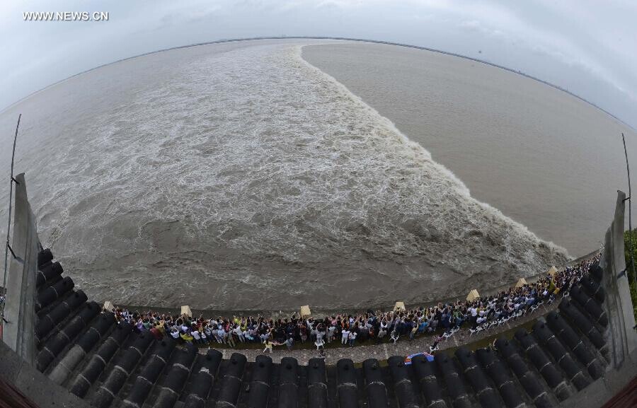 Des spectateurs rassemblés sur les rives du fleuve pour admirer le mascaret de la rivière Qiantang à Yanguan (ville de Haining), dans la Province du Zhejiang à l'Est de la Chine, le 11 septembre 2014. C’est lors du huitième mois du calendrier lunaire chinois que le mascaret de la rivière Qiantang voit déferler les plus hautes vagues. (Xinhua / Han Chuanhao)