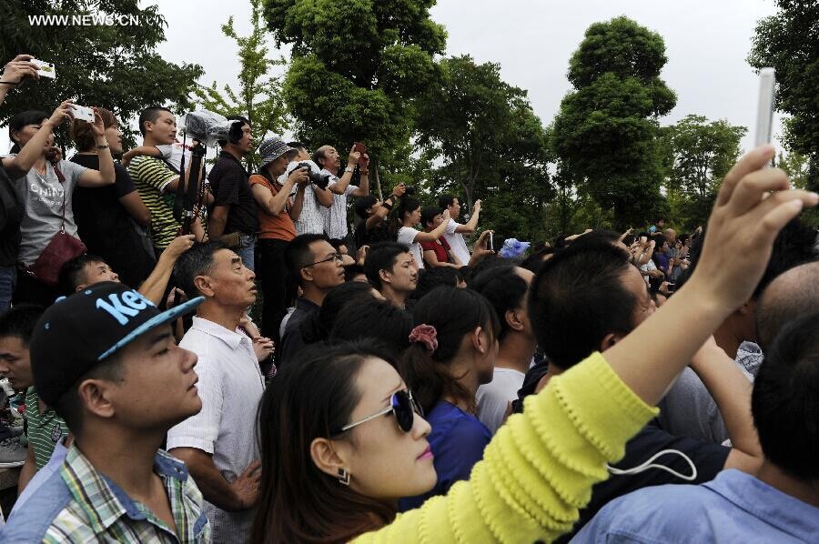 Des spectateurs rassemblés sur les rives du fleuve pour admirer le mascaret de la rivière Qiantang à Yanguan (ville de Haining), dans la Province du Zhejiang à l'Est de la Chine, le 11 septembre 2014. C’est lors du huitième mois du calendrier lunaire chinois que le mascaret de la rivière Qiantang voit déferler les plus hautes vagues. (Xinhua / Han Chuanhao)