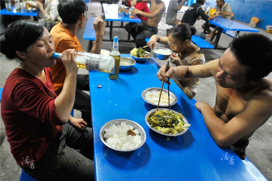 Yang Yashan savoure une bière alors que son mari d?ne. La cantine sur le site de construction propose des repas à partir de 8 yuans (un peu plus d'un euro) par personne. [Photo/qq.com]