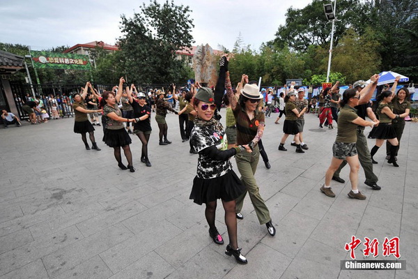 Une fillette se laisse entrainer dans un groupe qui pratique ? la danse des zombies ?. Photo Jin Shuo pour Xinhua. 