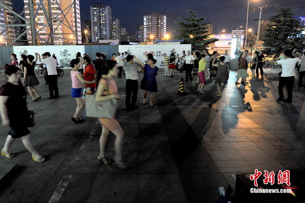 La danse de square ? Centre de l'univers ? devant le centre commercial Joy City de Shuangjing. Ici se réunissent tous les soirs à 19h trois générations de danseurs qui arrivent petit à petit, formant toutes sortes de petits groupes séparés de danse de square, qui ont t?t fait de remplir cet endroit. Photo Jin Shuo pour Xinhua. 