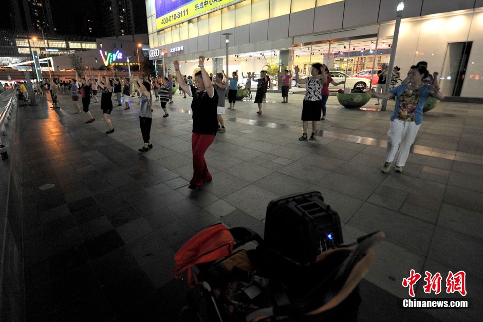 La danse de square ? Centre de l'univers ? devant le centre commercial Joy City de Shuangjing. Ici se réunissent tous les soirs à 19h trois générations de danseurs qui arrivent petit à petit, formant toutes sortes de petits groupes séparés de danse de square, qui ont t?t fait de remplir cet endroit. Photo Jin Shuo pour Xinhua. 