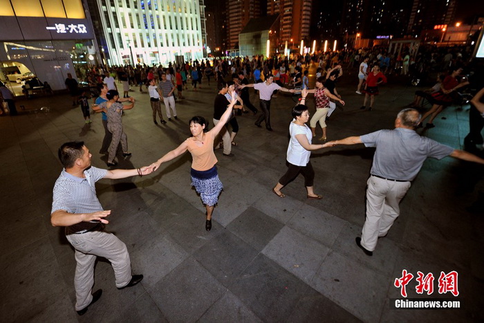 La danse de square ? Centre de l'univers ? devant le centre commercial Joy City de Shuangjing. Ici se réunissent tous les soirs à 19h trois générations de danseurs qui arrivent petit à petit, formant toutes sortes de petits groupes séparés de danse de square, qui ont t?t fait de remplir cet endroit. Photo Jin Shuo pour Xinhua. 