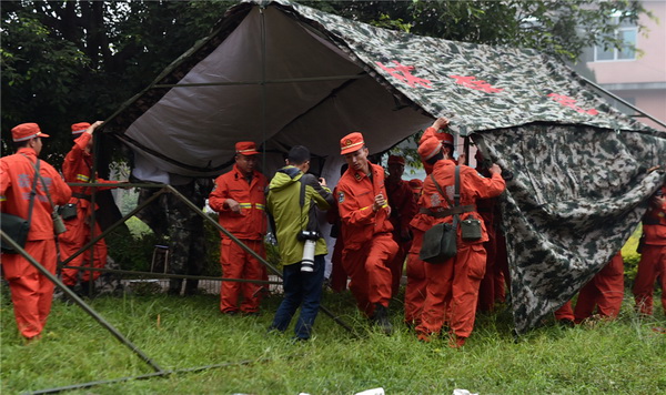 Des secouristes installent des tentes sur les lieux de l'épicentre du tremblement de terre, dans la commune de Yongping (Comté de Jinggu, ville de Pu'er), dans la Province du Yunnan (Sud-ouest de la Chine), le 8 octobre 2014 après qu’un séisme de magnitude 6,6 ait secoué Jinggu, mardi à 21h49 (13h49 GMT). Pour l’heure, la catastrophe a fait un mort et 336 blessés, dont huit enfants gravement atteints.