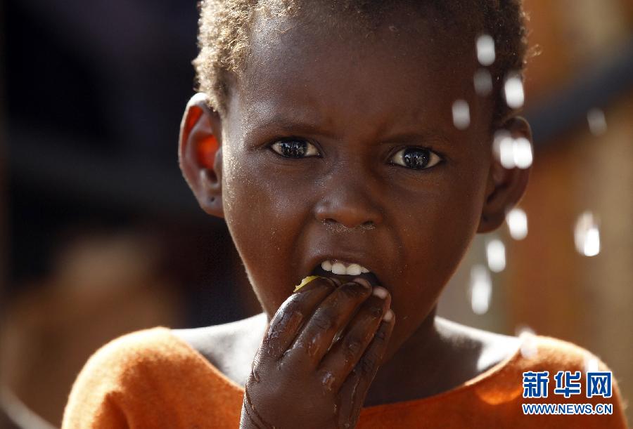 Le 28 juin 2012, un gar?on prends son repas à l’extérieur d’une tente à Mogadiscio, la capitale de la Somalie.