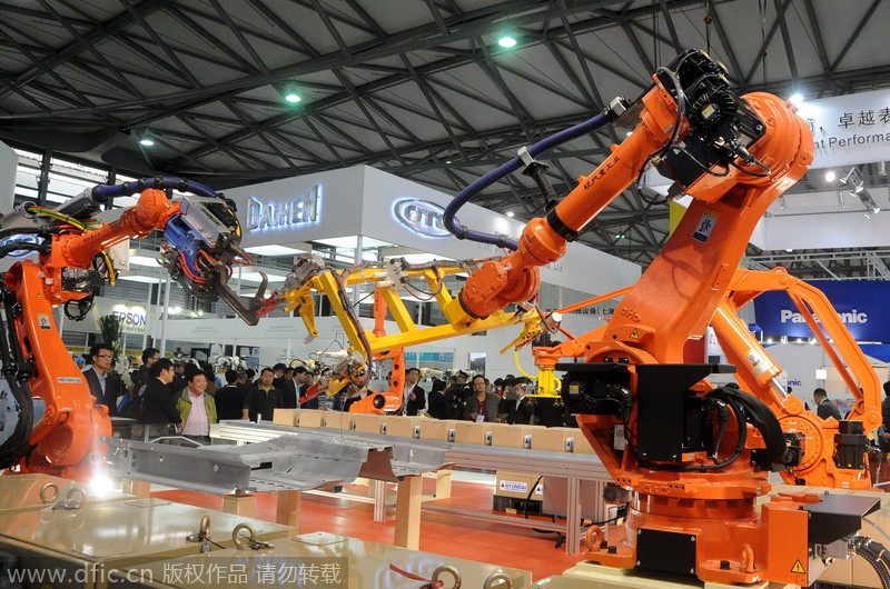 Deux robots de cha?ne de montage font une démonstration le transfert d'objet pendant le 16e Salon international de l'industrie de Chine à Shanghai, le 4 novembre 2014. 