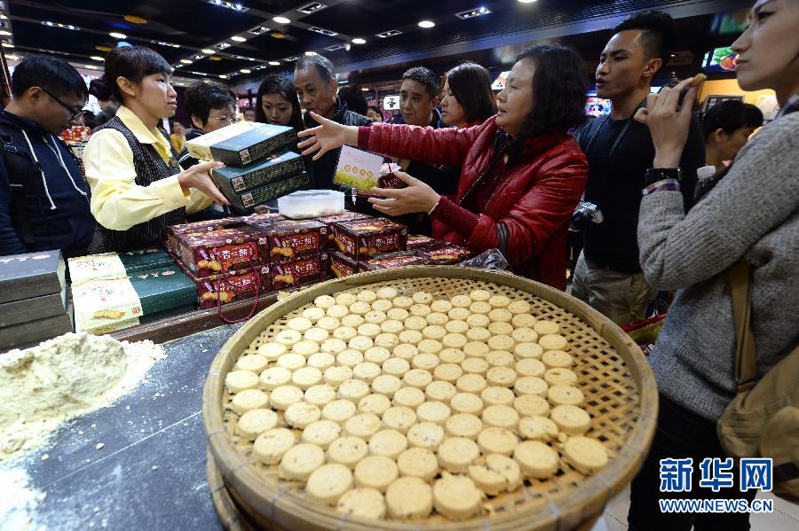 Des touristes achètent des gateaux aux amandes, une patisserie traditionnelle de Macao.