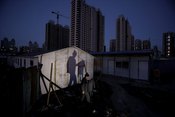 Un ouvrier récupère ses vêtements secs sur un chantier de construction dans le district de Chaoyang à Beijng, le 7 décembre 2014.