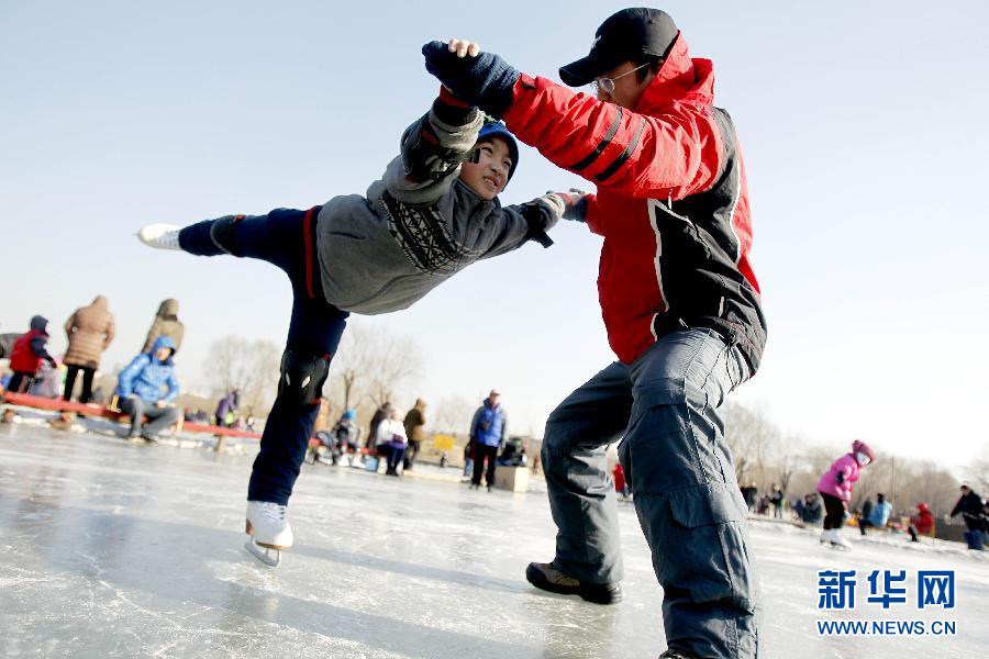 Un petit gar?on pratique le ski sous la direction d’un enseignant au Parc Wanliutang à Shenyang, le 1er janvier 2015.