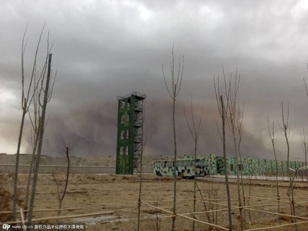 Mardi soir, une tempête de sable, qui a couvert le ciel pendant près d'une demi-heure, a éclipsé de hauts immeubles de la ville de Golmud, la province du Qinghai. [Photo/CFP]