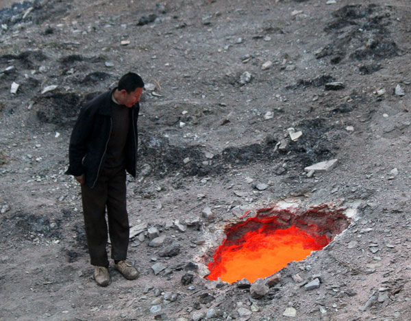 Un homme regarde à l'intérieur de cet ab?me de feu. [Photo / CFP]