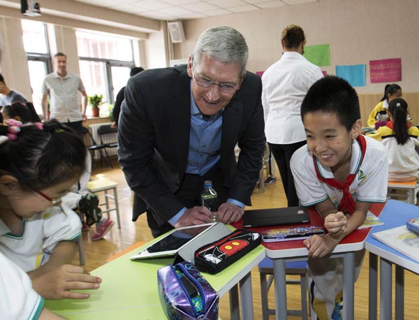 Tim Cook, le PDG d’Apple Inc, parle avec des élèves dans une classe de l'éducation numérique à l'école primaire de l'Université de Communication de Chine à Beijing, le 12 mai 2015. Cook a également rencontré le vice-Premier ministre Liu Yandong, celle-ci a exprimé son appréciation sur les recherches innovantes d’Apple après la succession de Cook à Steve Jobs. [Photo / Xinhua]