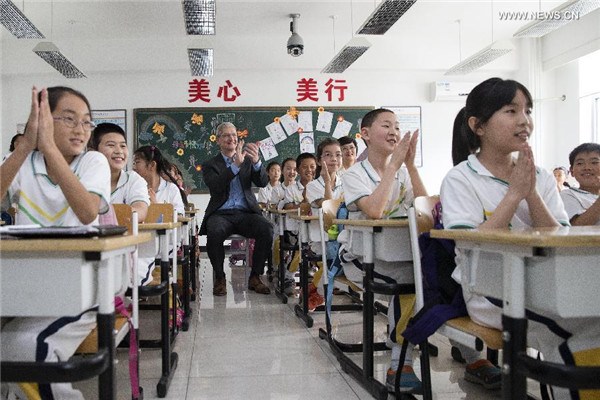 Tim Cook, au fond de la classe, assiste à une le?on d'anglais oral à l'école primaire de l'Université de Communication de Chine, le 12 mai 2015. [Photo / Xinhua]