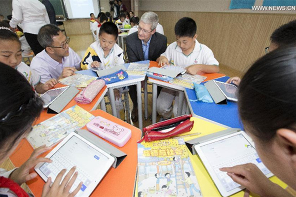 Tim Cook, au centre, assiste à une le?on à l'école primaire de l'Université de Communication de Chine, le 12 mai 2015. [Photo / Xinhua]