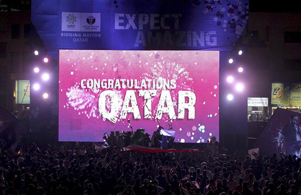 Des gens font la fête en face d'un écran où on peut lire ? Félicitations au Qatar?? après que la FIFA ait annoncé que le Qatar sera l'h?te de la Coupe du Monde 2022 à Souq Waqif, à Doha (photo d’archives du 2 décembre 2010). [Photo / Agences]