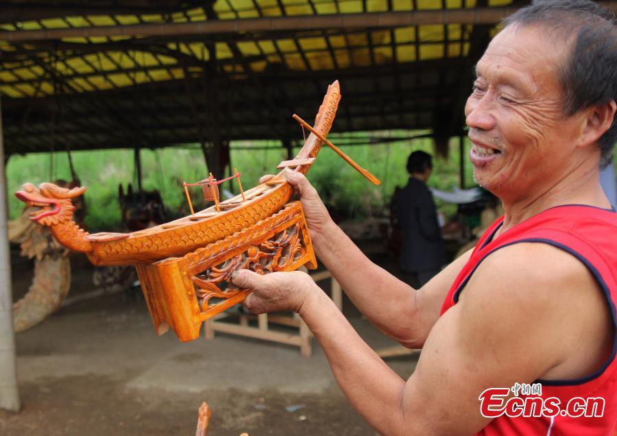 Zhou Chengyun, un artisan, met la touche finale à une sculpture qui sera utilisée dans une course de bateaux-dragons, dans le comté de Daoxian de la province du Hunan, en Chine centrale. Quelques jours avant la Fête des bateaux-dragons du 20 juin, Zhou et sa femme se sont lancés dans une course contre la montre afin de fabriquer cinq nouvelles têtes de dragon pour la course de bateaux et en rénover huit anciennes. Le comté de Daoxian est renommé pour sa fabrication de bateaux-dragons.