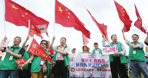 Des résidents agitent des fleurs d'arbres d'orchidées, l’emblème de Hong Kong, lors d'un rassemblement en faveur de la réforme électorale à Hong Kong, le 17 ao?t 2014. [Photo/Xinhua]