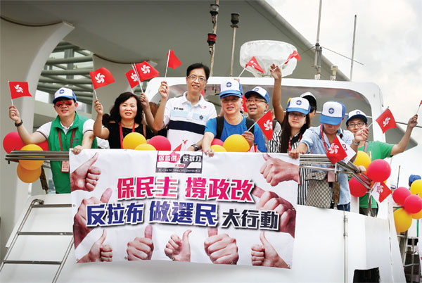 Des résidents agitent des fleurs d'arbres d'orchidées, l’emblème de Hong Kong, lors d'un rassemblement en faveur de la réforme électorale à Hong Kong, le 17 ao?t 2014. [Photo/Xinhua]