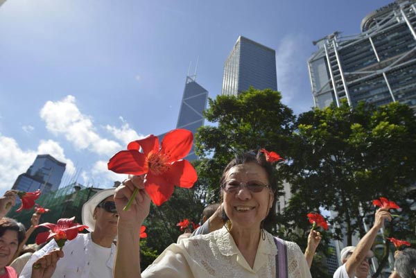 Des résidents agitent des fleurs d'arbres d'orchidées, l’emblème de Hong Kong, lors d'un rassemblement en faveur de la réforme électorale à Hong Kong, le 17 ao?t 2014. [Photo/Xinhua]