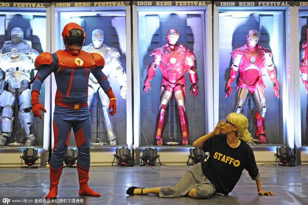 Une femme en T-shirt noir pose pour une photo avec Tianjin Hero022 lors du Trendy Tianjin Comic Con à Tianjin, dans le Nord de la Chine, le 24 juillet 2015. [Photo / CFP]