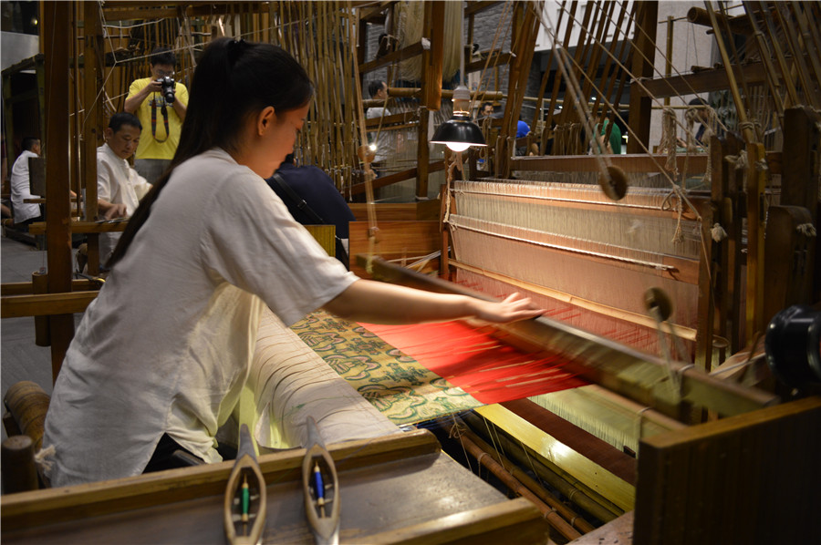 Une apprentie travaille sur un métier à tisser de brocard de Shu au Musée du brocard et de la broderie de Shu de Chengdu, dans la Province du Sichuan, le 13 ao?t 2015. Ce processus complexe et demandant beaucoup de temps donne naissance à l’exquis brocard de Shu. [Photo Jiang Wanjuan / chinadaily.com. cn]