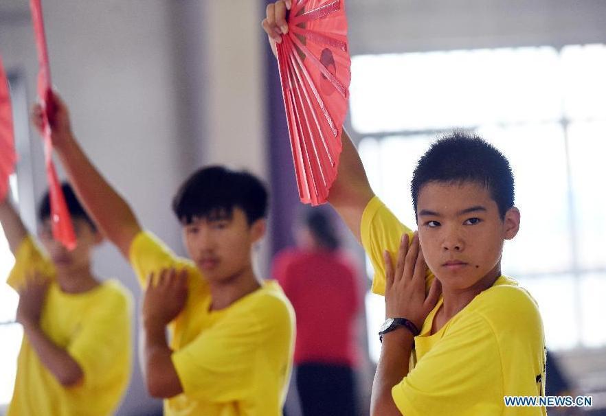 Des jeunes apprennent le tai-chi Kung Fu Fan pendant leur camp d'été