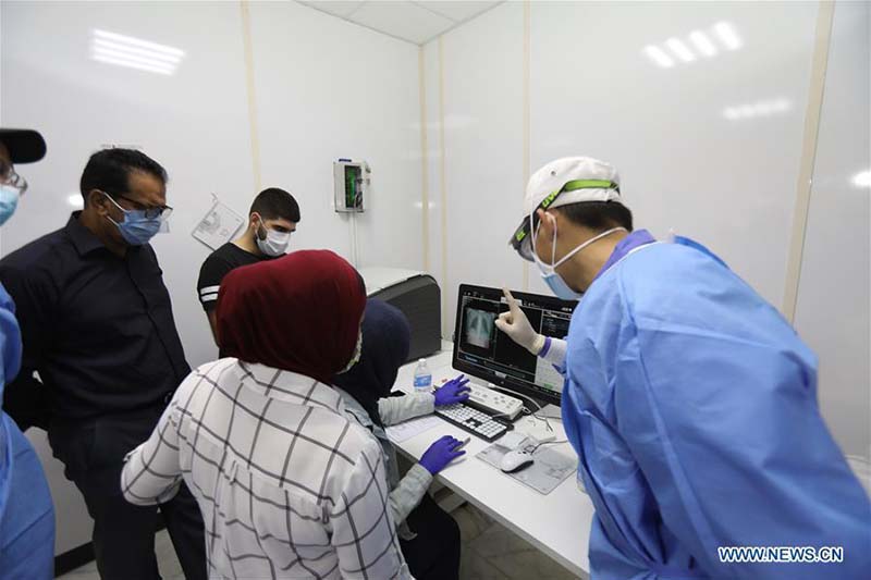 Des experts médicaux chinois installent un tomodensitomètre pour aider à lutter contre le COVID-19 en Irak