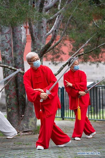 Les personnes agées pratiquent l'aérobic traditionnel au parc du Temple du Ciel à Beijing