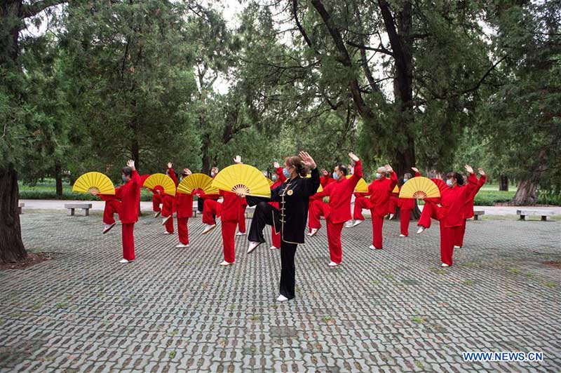 Les personnes agées pratiquent l'aérobic traditionnel au parc du Temple du Ciel à Beijing