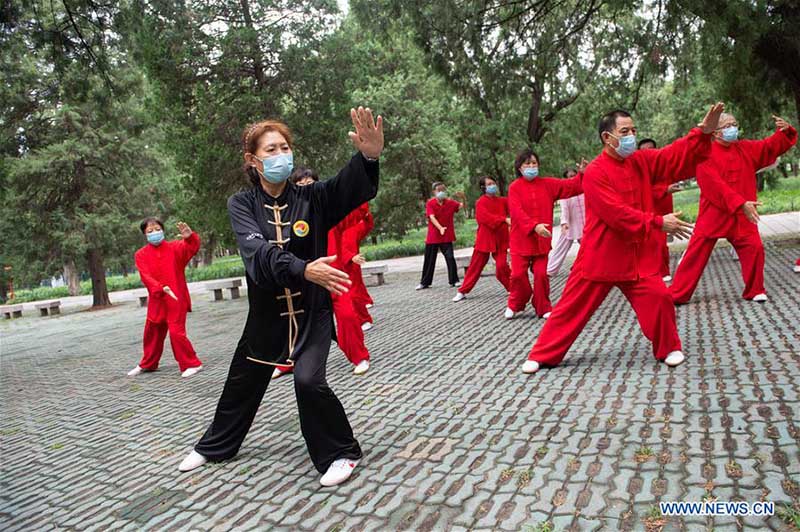 Les personnes agées pratiquent l'aérobic traditionnel au parc du Temple du Ciel à Beijing