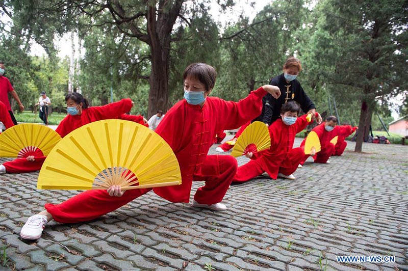 Les personnes agées pratiquent l'aérobic traditionnel au parc du Temple du Ciel à Beijing