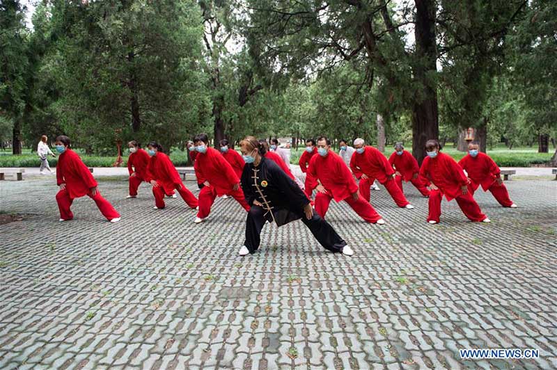 Les personnes agées pratiquent l'aérobic traditionnel au parc du Temple du Ciel à Beijing