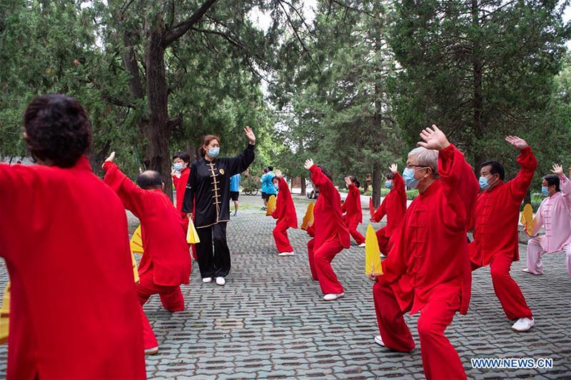 Les personnes agées pratiquent l'aérobic traditionnel au parc du Temple du Ciel à Beijing