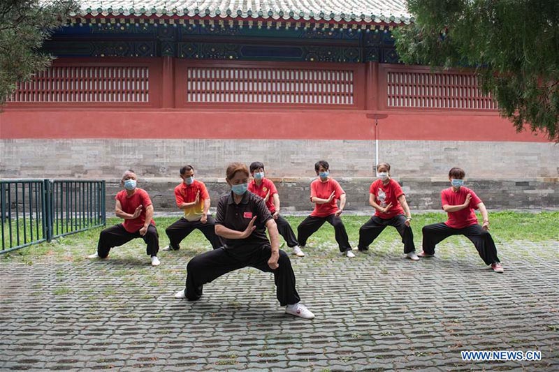 Les personnes agées pratiquent l'aérobic traditionnel au parc du Temple du Ciel à Beijing